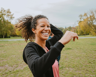 A woman outdoors on a field smiling